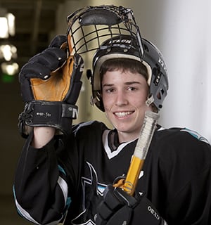 Teenager wearing protective gear for hockey.